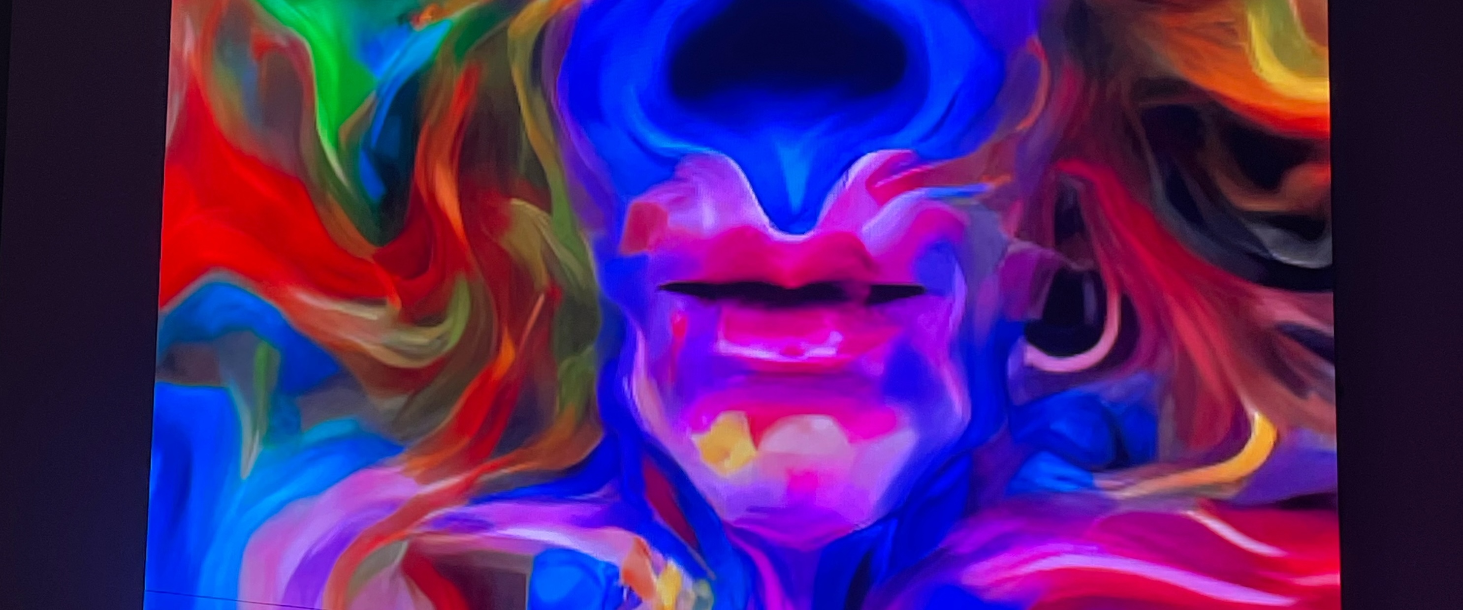 Viele bunte und verschwommene Formen lassen ein Gesicht erahnen.