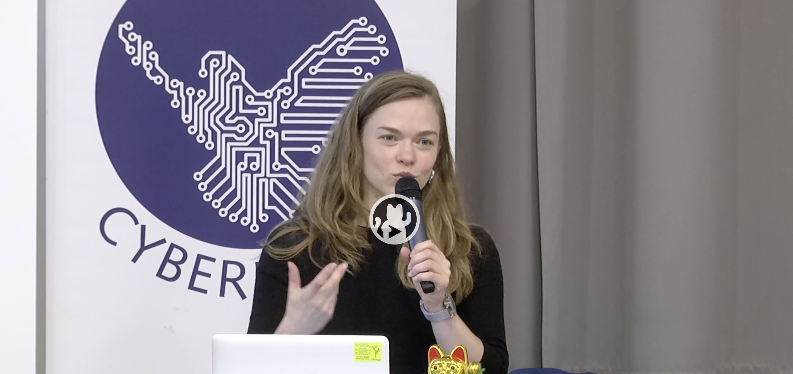 Eine Frau mit langen braunen Haaren hält ein Mikrofon in der Hand