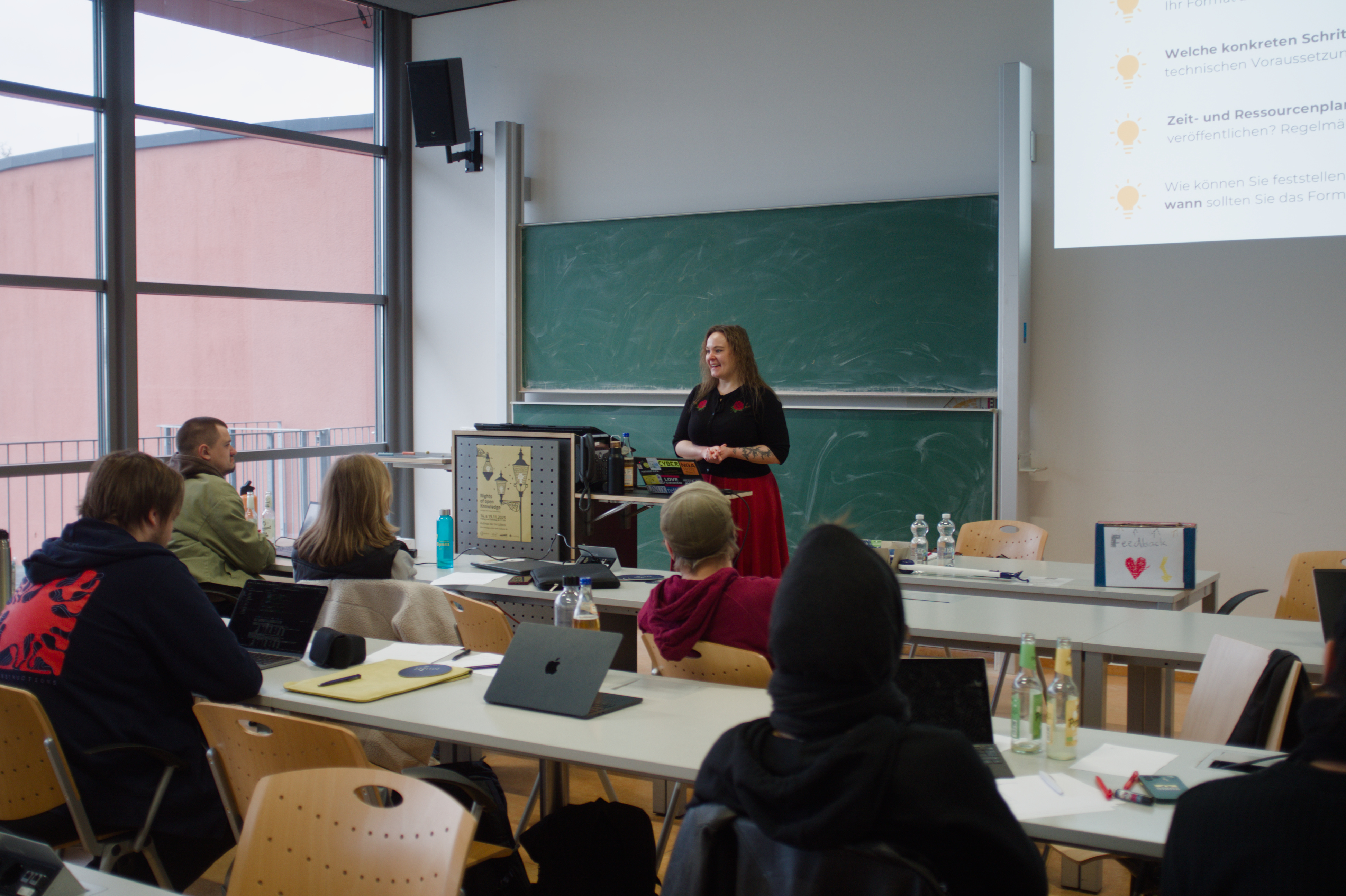Blick auf Lea und die zuhörenden Personen von Hinten.
