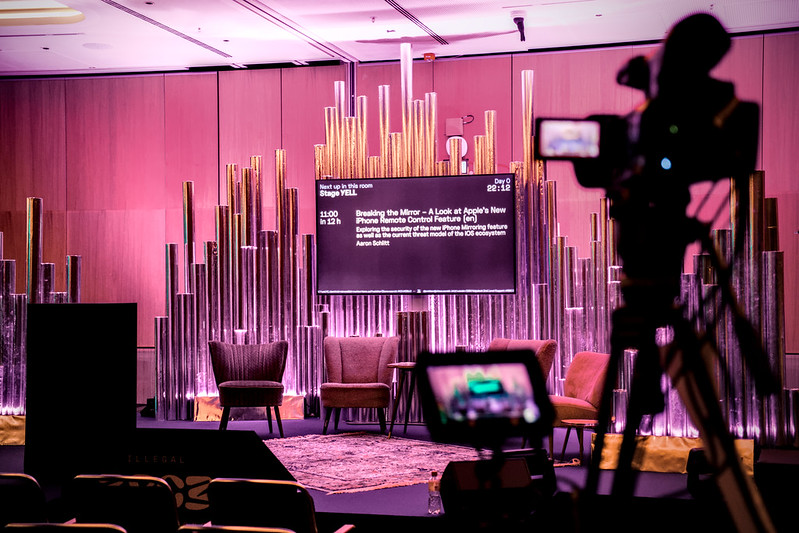 Ein Video-Streaming Set up. Eine Kamera ist auf eine Gruppe Sessel und einen Fernseher gerichtet.